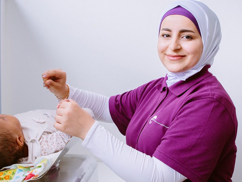 Fatima Ibrahim, Auszubildende in der Kinderarztpraxis im Johannistal Aachen, wiegt ein Baby